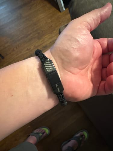 Customer showing their black paracord bracelet with a sturdy metal clasp on their wrist.