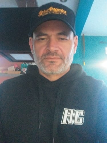 Un client portant le Hoodie HC Argenté noir, montrant le logo sur la poitrine.