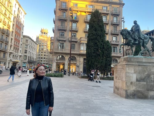 Reviewer in a sunny city square, her skin appearing smooth after using SkinCeuticals Triple Lipid Restore.