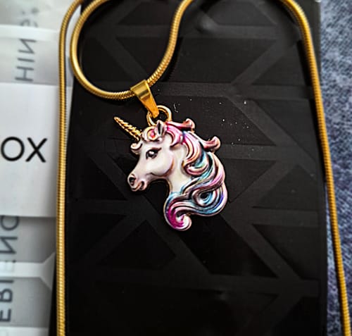 Customer's close-up of the Unicorn Necklace, showing the detailed multicolored unicorn pendant on a gold-tone chain.