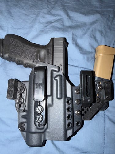 A customer's black APX holster holding a handgun, with the adjustable magazine carrier attached to the side.