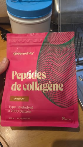 Un client tient le sachet rose de Peptides de Collagène saveur chocolat dans sa main.