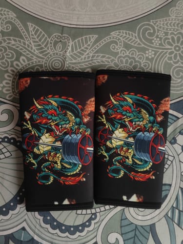 Reviewer's pair of black Dragon Fury knee sleeves laid flat, showing the colorful dragon and barbell design.