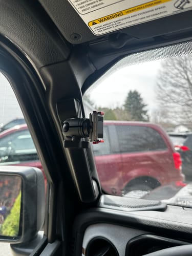Reviewer's 20mm ball mount installed on the A-pillar inside their vehicle, ready to hold a device.