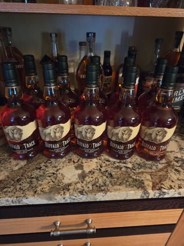 Customer's full case of Buffalo Trace Bourbon Whiskey bottles lined up on a granite countertop.