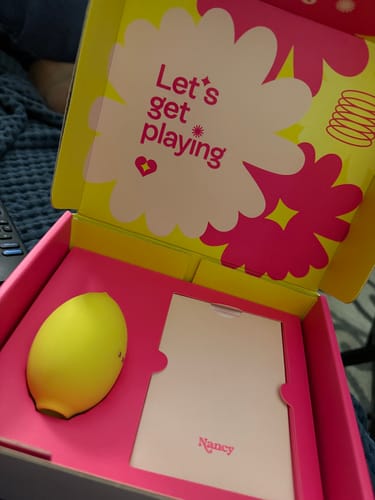 Customer's yellow Lem Clitoral Massager resting inside its colorful open box.