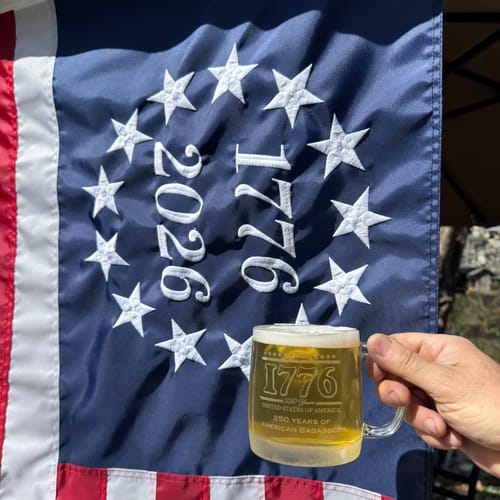 Close-up: Reviewer's hand holds a mug before the Betsy Ross flag from the Patriotic Decor Kit.