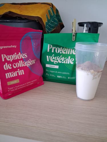 Un client montre son sachet de Protéine Végétale Bio à côté d'un shaker prêt à être mélangé.