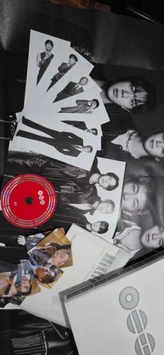 Customer displays the contents of their BTS ARIRANG 5TH ALBUM, showing the red CD, posters, and photo cards.