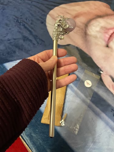 Customer holding the BTS Arirang Luxury Hair Stick, showing its large size and ornate top with a lavender stone.