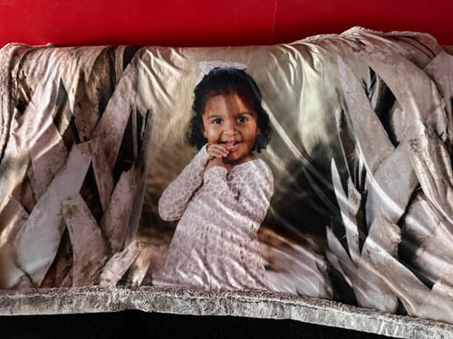 Customer's custom photo blanket featuring a smiling child in the center and a coconut snow bunny border.