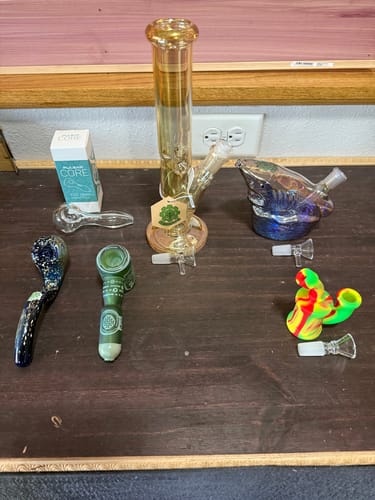 Customer displays the contents of their Mystery Box, including a large bong, dab rig, and various glass and silicone pipes.