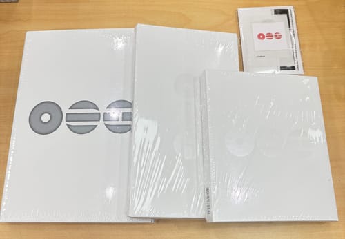 Customer's BTS - ARIRANG album set showing the three sealed, white album versions on a table.