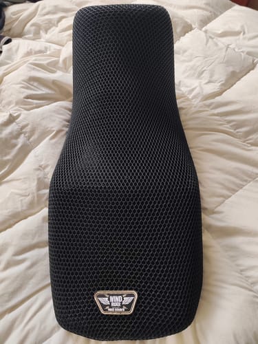 Reviewer's black Wind Rider Seat Cover, with its textured mesh design, shown before installation.