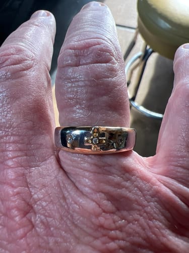 Close-up of a reviewer wearing the two-tone gold cross ring, showing the gem-studded cross detail.