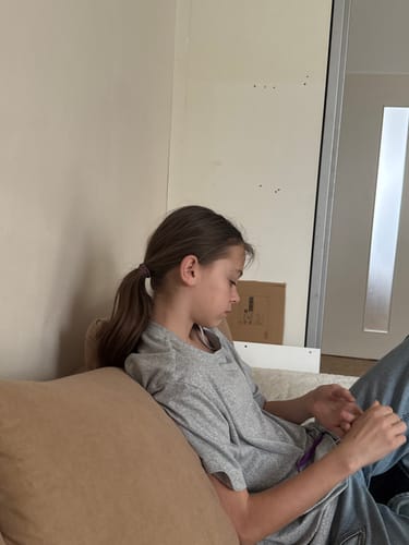 Foto eines Rezensenten, das eine Person zeigt, die auf einer Couch sitzt.