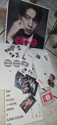 Customer showing the contents of the BTS - ARIRANG 5TH ALBUM set, including a large poster, photocards, and other merchandise.
