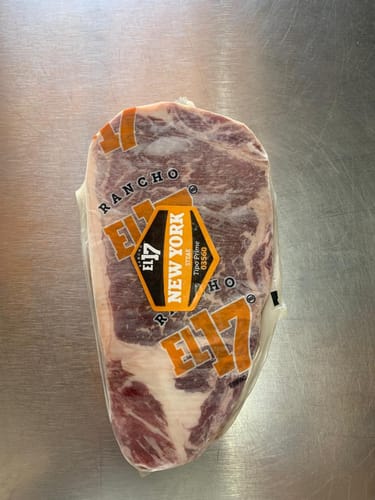 Cliente muestra el New York Steak Prime crudo y sellado al vacío en su empaque.