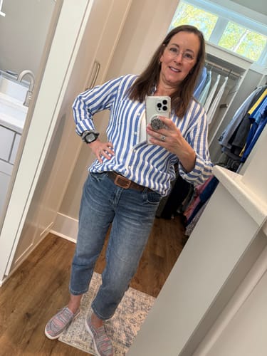 Reviewer wearing the brown leather Lainey belt with cropped jeans and a blue and white striped shirt.