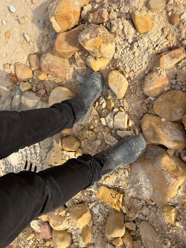 Reviewer standing on rough, rocky terrain in their black Grittgear Slate Safety Boots.