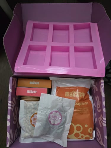Customer's open Craft Subscription Box revealing a soap-making kit with a pink mold and other supplies.