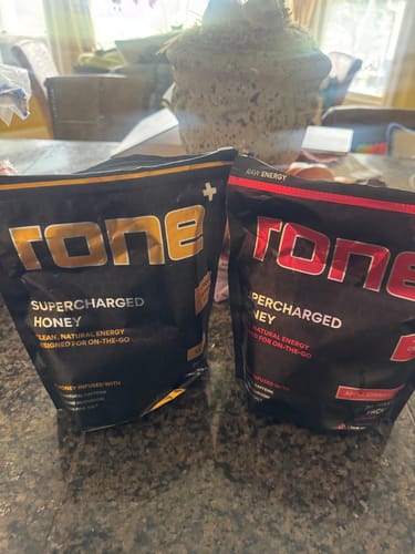 Customer's two different pouches of SuperCharged Honey sitting side-by-side on a kitchen counter.