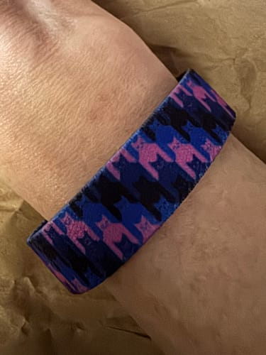 Reviewer's close-up of the colorful Meow or Never Bracelet on their wrist, showing the subtle cat pattern.