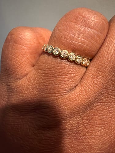 Close-up of a reviewer wearing the gold Chunky Caviar eternity band on their finger.