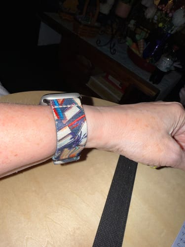 Close-up of a customer wearing the colorful patterned Bookish Watchband on their wrist.