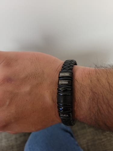 Customer's wrist wearing the black bracelet, personalized with several engraved name beads.