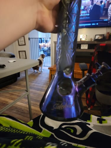 Reviewer holding the Gear Premium Sidekick Beaker Bong, showing its iridescent Terminator finish and textured neck.