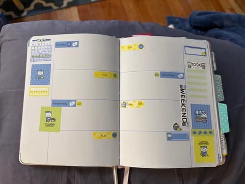 Customer's open weekly planner decorated with cute blue and yellow stickers from the Ultimate Subscription box.