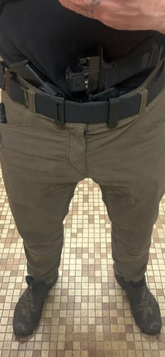 Reviewer wearing the APX holster with a firearm and spare magazine in an appendix carry position.