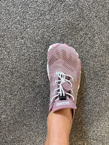 Customer's foot wearing the pink Smart II Barefoot Shoe with white laces, seen from above.