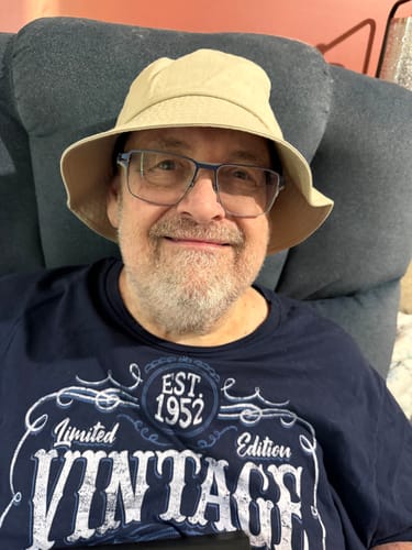 Reviewer smiling while seated, wearing the light-colored Big Standard Bucket Hat.