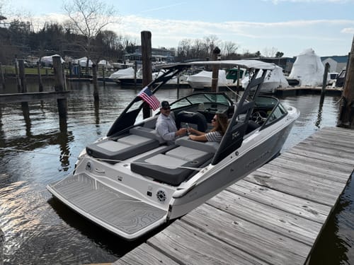Customer's American Flag mounted on a boat with two people aboard, docked at a marina.