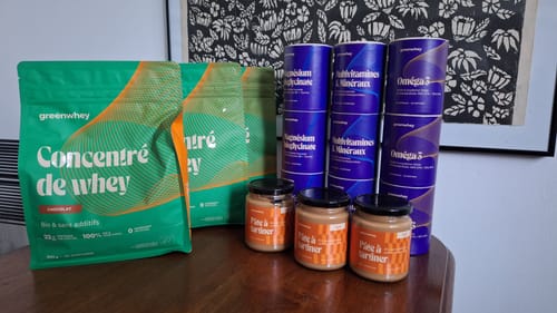 Avis du client : les tubes bleus d'Oméga 3 EPAX® sur une table avec d'autres produits Greenwhey.