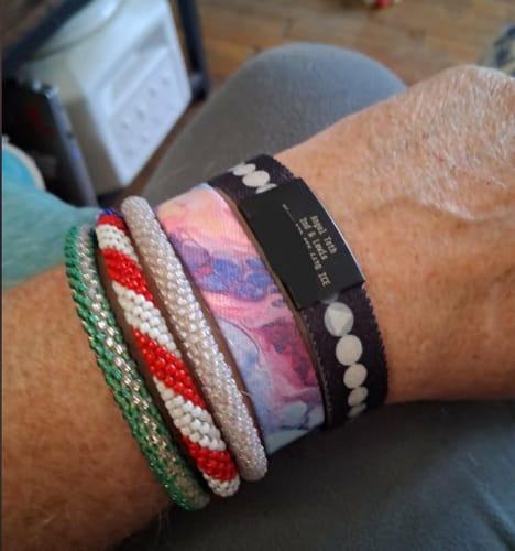 Customer wearing the Just For Today Bracelet on their wrist, stacked with other colorful, beaded bracelets.