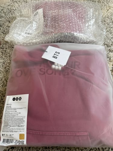 Customer's BTS ARIRANG hoodie in its original clear packaging, with a cap in bubble wrap.