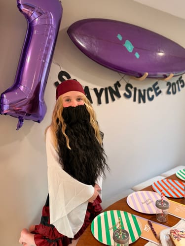 A reviewer's child in a fun pirate costume with a large beard for the Kids Murder Mystery Game Kit party.