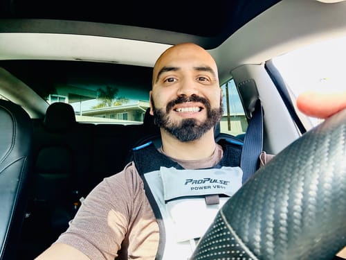 Reviewer smiling in a car while wearing the gray and black ProPulse® Power Vest.