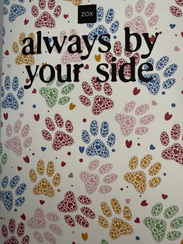 Customer's April 2026 Booklet showing the cover with 'always by your side' text over colorful paw prints made from hearts.