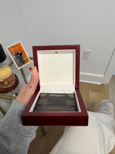 Customer holding the open mahogany box from the Forever Love Gift Set, showing the black message card inside.