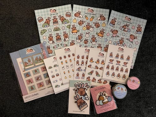 Reviewer's cute Capy Easter Bundle laid out, showing all the sticker sheets, washi tapes, and the enamel pin.