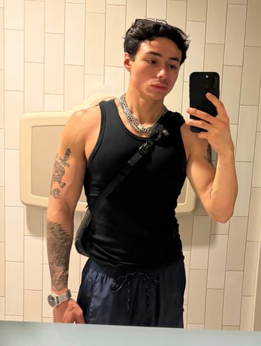 Reviewer in a mirror selfie showing the fit of the black Premium Ultra-Soft Cotton Fitted Tank.