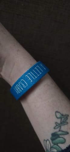 Close-up of a reviewer wearing the blue 'A Little Crabby' bracelet on their wrist.