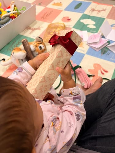 Customer's child holding the gift-wrapped box for the Silver Sparkling Kids Anklet.