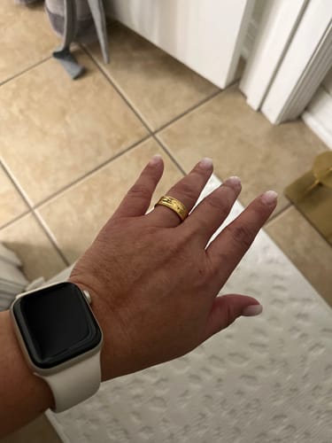 Customer's hand wearing the textured gold Regalia Ring.