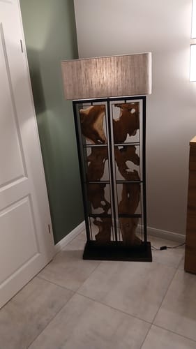 Kundenbewertung der Stehlampe Teakholz RUBIX, die eingeschaltet in einer Zimmerecke steht.