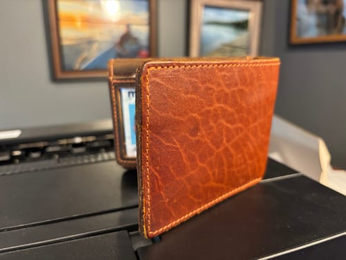 Customer's brown Powell Bison Bifold wallet showing the textured leather grain.